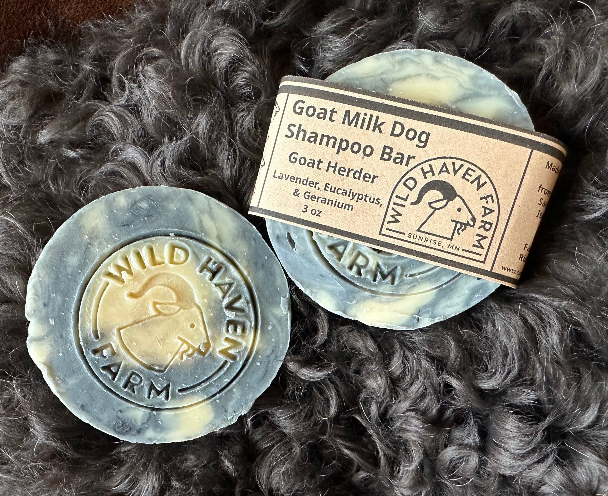 two round bars of shampoo laying on black curly fur